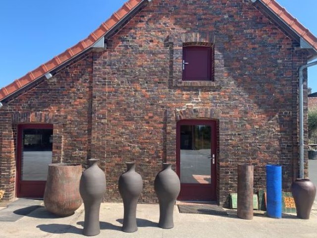 Grandes pièces de Ceramic Factory devant la façade en briques de la manufacture Raoult Fils